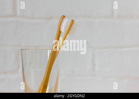 Zwei Bambuszahnbürsten in einem Glas mit einer Kopie des Raumes.Nahaufnahme Stockfoto