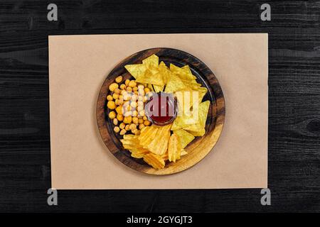 Große Auswahl an Snacks für Bier mit verschiedenen Saucen auf Pergament Draufsicht Stockfoto