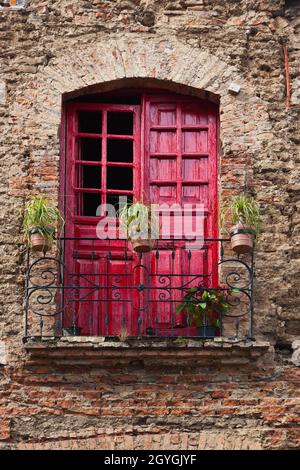 Balkontüren sind in TLAQUEPAQUE - GUADALAJARA, MEXIKO, leuchtend rot gestrichen Stockfoto