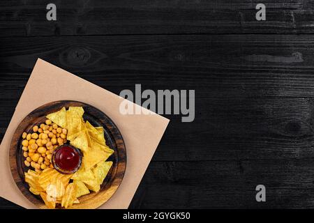 Große Auswahl an Snacks für Bier mit verschiedenen Saucen auf Pergament Draufsicht Stockfoto
