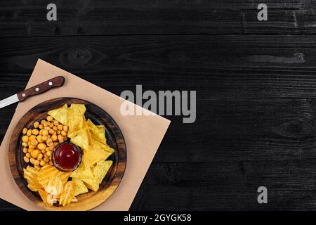 Große Auswahl an Snacks für Bier mit verschiedenen Saucen auf Pergament Draufsicht Stockfoto