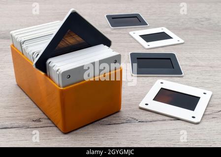 Alte Objektträger in einer Kunststoffbox. Vintage-35-mm-Diafilm auf Holztisch. Stockfoto