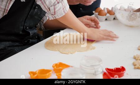 Enkelin Whit Großmutter bereitet köstliche Lebkuchen Dessert mit Kochen Form Backen in Weihnachten dekorierten Küche. Glückliche Familie genießen Wintersaison feiern weihnachtsferien Stockfoto