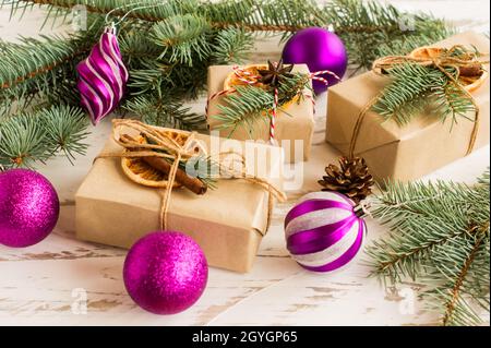 Neujahrs- oder Weihnachtsgeschenkschachteln mit traditionellen festlichen organischen Dekorationen, mit eigenen Händen hergestellt. Fichtenzweige und Spielzeug Stockfoto