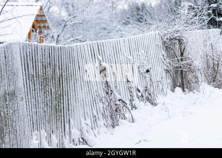 Russische Winter ländliche Landschaft Foto mit verschneiten Holzzaun an einem Tag Stockfoto