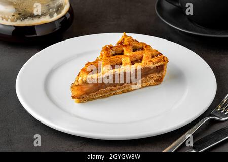 Köstliche Apfeltarte und Kaffee auf dunklem Steinboden Stockfoto