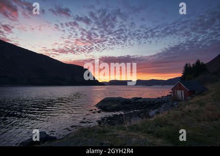 Sonnenuntergang auf dem Fjord von Selje Norwegen. Sehr schöne Farben spiegeln sich in den Wolken und dem Wasser. Angelurlaub in fantastischer Landschaft Stockfoto