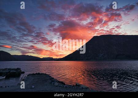 Sonnenuntergang auf dem Fjord von Selje Norwegen. Sehr schöne Farben spiegeln sich in den Wolken und dem Wasser. Angelurlaub in fantastischer Landschaft Stockfoto