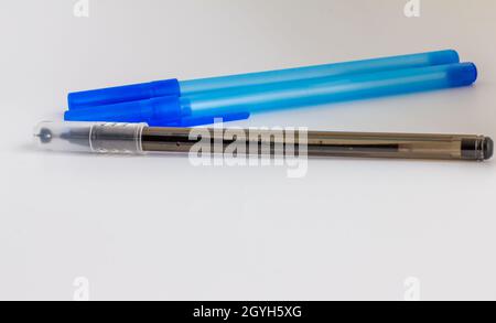 3 Kugelschreiber mit blauen und schwarzen Kappen, isoliert auf weißem Hintergrund Stockfoto