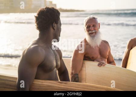 Multi-Generationen-Surfer-Männer mit Spaß am Strand - Fokus auf afrikanischen Mann Stockfoto