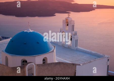 Kirche mit blauem Kuppeldach und weißem drei Glockenturm am Krater, dahinter die Vulkaninsel Nea Kameni, Firofestani, Thira, Santorini, Cycl Stockfoto