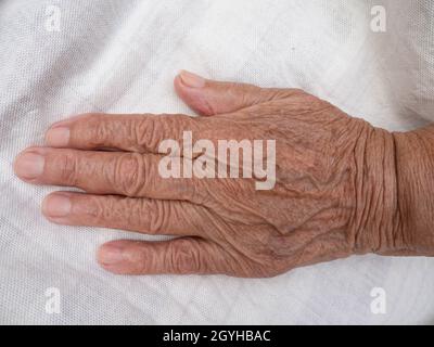 Die Hand eines älteren Mannes auf weißem Hintergrund Stockfoto