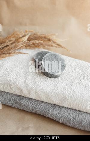Feste Shampoo-Bars aus natürlichen Zutaten auf flauschigen Handtüchern, kein Kunststoff, kein Abfallprodukt. Stockfoto