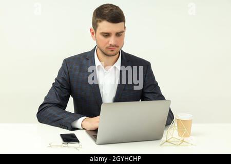 Geschäftskonzept mit einem jungen Mann, der am Laptop arbeitet. Stockfoto