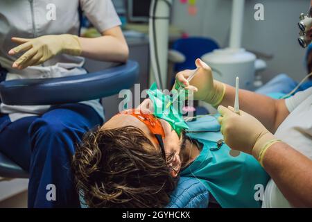 Mann, der Zähne bei Zahnärzten untersucht hat. Zahnärztliche Behandlung in der Zahnmedizin. Termin beim Zahnarzt. Lifestyle, echtes Leben Stockfoto