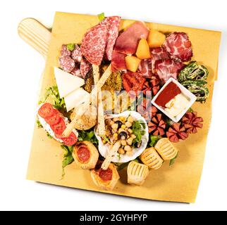 Gemischte Antipastplatte mit Aufschnitt, Hülsenfrüchten und Käse auf weißem Hintergrund Stockfoto