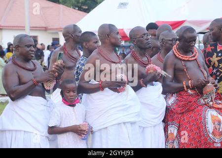 Traditionelle Menschen im Königreich Benin während einer Ausstellung der historischen Artefakte von Oba Ewuare 1 des Benin-Reiches von 1440 bis 1473 in einem Museum in Benin City, Edo, Bundesstaat Nigeria. Lukas Osarobo Okoro, ein multidisziplinärer Künstler, zeigt zusammen mit einigen Mitgliedern der Ahiamwen Guild of Artists die bisher größte bronzene Pest des alten Benin-Königreichs, die 2 Tonnen wiegt. Nigeria. Stockfoto