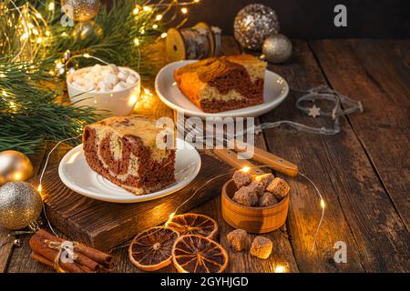 Festlicher Kuchen auf einem weihnachtlichen Hintergrund mit Lichtern. Das Konzept von Weihnachten und Neujahr. Seitenansicht, Kopierbereich. Stockfoto