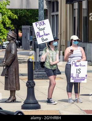 Montgomery, Alabama, USA - 2. Oktober 2021: Zwei Protesterinnen halten ihre Zeichen, während sie neben der Rosa Parks Statue in der Innenstadt von Montgomery stehen Stockfoto