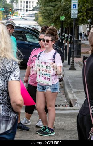 Montgomery, Alabama, USA - 2. Oktober 2021: Junge Frau protestiert mit einem Schild in der Innenstadt von Montgomery für den Frauenmarsch 2021. Stockfoto