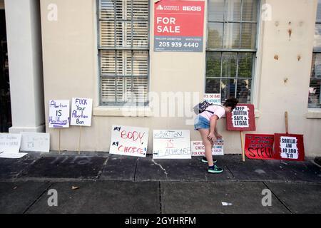 Montgomery, Alabama, USA - 2. Oktober 2021: Eine einreisende Frau setzt ihr Zeichen gegen die Wand. Die Demonstranten wurden gezwungen, ihre Zeichen für den Wom 2021 aufzugeben Stockfoto