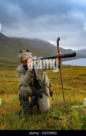 Ross-Shire, Scottish Highlands, Großbritannien. Oktober 2021. Nachdem die Red Stag-Saison in wenigen Tagen zu Ende geht, beginnt Rob Dhu A Ghillie in den schottischen Highlands, um Red Deer an einem nebligen nassen Morgen auf einem abgelegenen Hügel in Ross-Shire mit dem traditionellen Spionageglas oder -Teleskop zu suchen. Quelle: Matt Limb OBE/Alamy Live News Stockfoto