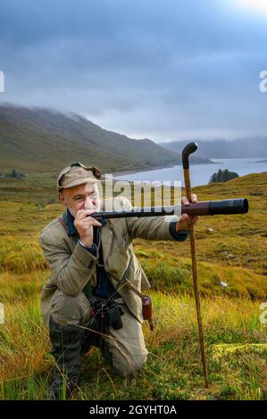 Ross-Shire, Scottish Highlands, Großbritannien. Oktober 2021. Nachdem die Red Stag-Saison in wenigen Tagen zu Ende geht, beginnt Rob Dhu A Ghillie in den schottischen Highlands, um Red Deer an einem nebligen nassen Morgen auf einem abgelegenen Hügel in Ross-Shire mit dem traditionellen Spionageglas oder -Teleskop zu suchen. Quelle: Matt Limb OBE/Alamy Live News Stockfoto