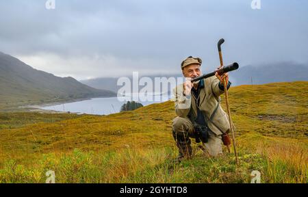 Ross-Shire, Scottish Highlands, Großbritannien. Oktober 2021. Nachdem die Red Stag-Saison in wenigen Tagen zu Ende geht, beginnt Rob Dhu A Ghillie in den schottischen Highlands, um Red Deer an einem nebligen nassen Morgen auf einem abgelegenen Hügel in Ross-Shire mit dem traditionellen Spionageglas oder -Teleskop zu suchen. Quelle: Matt Limb OBE/Alamy Live News Stockfoto