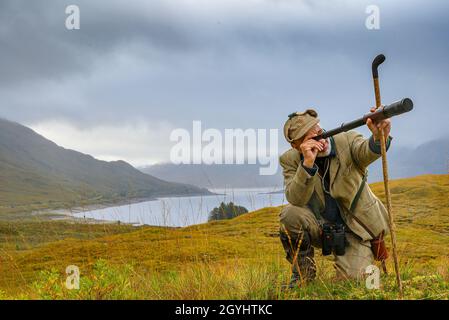 Ross-Shire, Scottish Highlands, Großbritannien. Oktober 2021. Nachdem die Red Stag-Saison in wenigen Tagen zu Ende geht, beginnt Rob Dhu A Ghillie in den schottischen Highlands, um Red Deer an einem nebligen nassen Morgen auf einem abgelegenen Hügel in Ross-Shire mit dem traditionellen Spionageglas oder -Teleskop zu suchen. Quelle: Matt Limb OBE/Alamy Live News Stockfoto