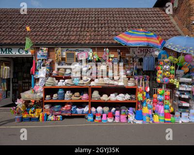 Bunte Touristen- und Strandzubehör-Schaufenster in Wells neben dem Meer an der North Norfolk Heriitage Coast in Norfolk England Stockfoto