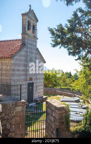 Podostrog, Budva - 23. September 2021: Kirche des heiligen Johannes des Theologen und Friedhof in der Nähe, Podostrog, Budva, Montenegro Stockfoto