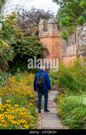 Mann spaziert im Herbstwald und genießt die herbstlichen Farben allein auf dem Land. Mann zu Fuß Bischöfe Garten chichester Kathedrale in der Herbstsaison Stockfoto