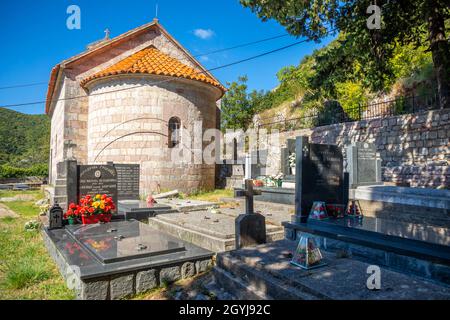 Podostrog, Budva - 23. September 2021: Kirche des heiligen Johannes des Theologen und Friedhof in der Nähe, Podostrog, Budva, Montenegro Stockfoto