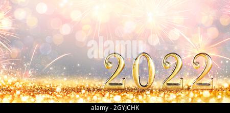 Neujahrsfeier 2022 - Goldene Zahlen Auf Glitzer Mit Feuerwerk Und Unfokussem Hintergrund Stockfoto