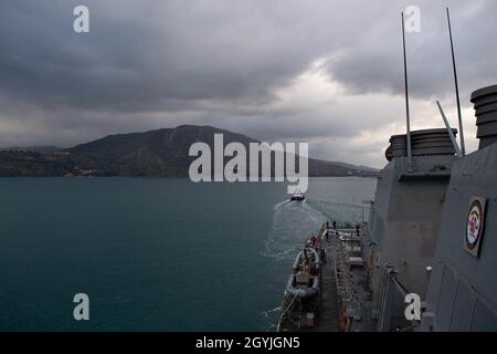 200103-N-CJ510-0219 SOUDA BAY, Griechenland (Jan 3, 2020) – Ein Schlepper unterstützt den Arleigh Burke-Klasse Lenkrakenzerstörer USS Ross (DDG 71), als er Souda Bay, Griechenland, verlässt, 3. Januar 2020. Ross, der im spanischen Rota stationiert ist, ist auf seiner neunten Patrouille im Einsatzgebiet der 6. US-Flotte zur Unterstützung der nationalen Sicherheitsinteressen der USA in Europa und Afrika. (USA Navy Foto von Mass Communication Specialist 3rd Class Andrea Rumple/veröffentlicht) Stockfoto