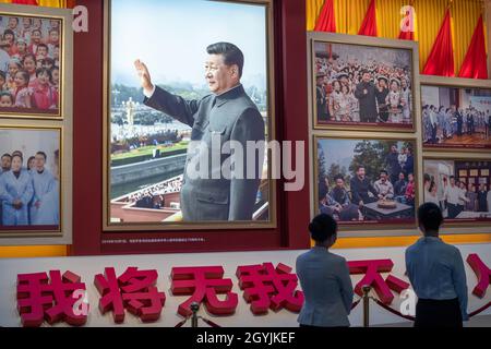 Die Menschen sehen sich Bilder an, die den chinesischen Präsidenten Xi Jinping im Museum der Kommunistischen Partei Chinas in Peking zeigen. 08-Okt-2021 Stockfoto