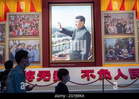Im Museum der Kommunistischen Partei Chinas in Peking gehen Menschen an Bildern vorbei, die den chinesischen Präsidenten Xi Jinping zeigen. 08-Okt-2021 Stockfoto