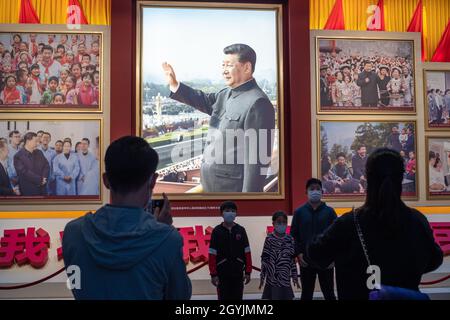 Die Menschen sehen sich Bilder an, die den chinesischen Präsidenten Xi Jinping im Museum der Kommunistischen Partei Chinas in Peking zeigen. 08-Okt-2021 Stockfoto