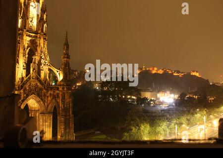 Edinburgh, Schottland bei Nacht: Schloss beleuchtet und Scott-Denkmal im Vordergrund Stockfoto