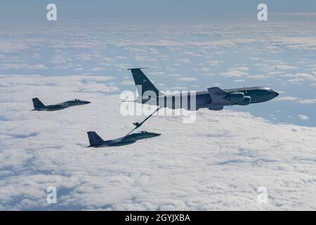 Zwei F-15C Eagles der 67. Fighter Squadron tanken mit einem KC-135 Stratotanker der 909th Air Refueling Squadron, 10. Januar 2020, während Der Übung Westpac Rumrunner von der Kadena Air Base, Japan. Die Übung Westpac Rumrunner bietet dem 18. Flügel die Möglichkeit, kritische Expeditionskillets mit gemeinsamen Partnern im indo-pazifischen Verantwortungsbereich zu überführen. (USA Luftwaffenfoto von Senior Airman Matthew Seefeldt) Stockfoto