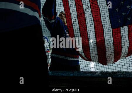 US Air Force Staff Sgt. Joshua Miller hilft beim Aufhängen einer amerikanischen Flagge vor der Eröffnungszeremonie des klassischen Hockeyspiels der Streitkräfte 2020 in der Sports World Southern Hills Ice Arena, Naha, Okinawa, Japan, 10. Januar, 2020. Die Armed Forces Classic wurde von Veterans Hockey United veranstaltet, um Dienstmitglieder zu präsentieren und das Bewusstsein für den Sport in Okinawa zu schärfen. Miller stammt aus Chambersburg, Pennsylvania, und ist ein F-15-Besatzungsleiter bei der 18. Wartungsgruppe, dem 18. Flügel und der 5. Luftwaffe. (USA Marine Corps Foto von CPL. Carla O) Stockfoto