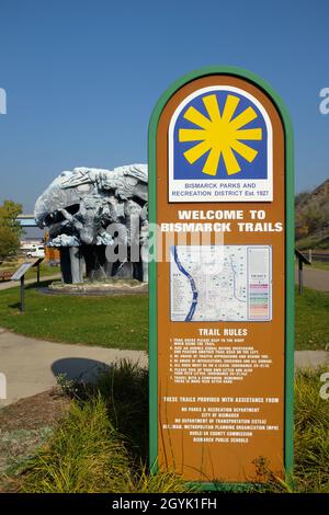 BISMARCK, NORTH DAKOTA - 3 Okt 2021: Bismarck Trails Willkommensschild im Keelboat Park mit der Thunderbirds Skulptur im Hintergrund. Stockfoto