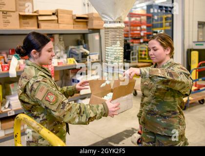 US Air Force Staff Sgt. Raven Driftmyer, links, und Staff Sgt. Brittany Robarge, rechts, Verkehrsmanagementspezialist, der dem 180th Fighter Wing der Ohio Air National Guard zugeordnet ist, füllt eine Schachtel mit Erdnüssen am 12. Januar 2020. Das Verkehrsmanagement-Büro ist für die Verarbeitung und Verwaltung von Fracht, Sendungen und Luftfrachten auf der ganzen Welt sowie für den Erhalt von Lieferungen für den Stützpunkt verantwortlich, damit die Luftwaffe ihre Mission überall auf der Welt erfüllen kann. (USA Foto der Air National Guard von Senior Airman Kregg York) Stockfoto