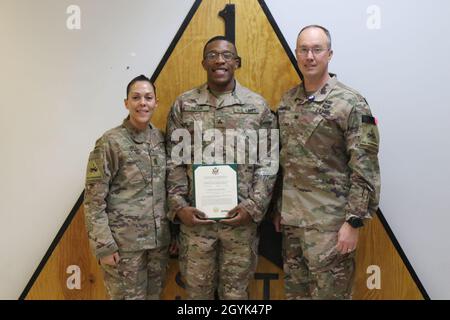 Sgt. Prince Dean, 1. Gepanzerte Division Sustainment Brigade, Posen mit Col. Ronnie D. Anderson, Kommandant, und Command Sgt.. Carla M. Hill, Senior Enlisted Advisor, 1st AD SB, nachdem er seine Beförderung auf dem Schlachtfeld zum Sergeant auf dem Bagram Air Field, Afghanistan, am 13. Januar 2020 erhalten hatte. (USA Armeefoto von Sgt. Briaira Tolbert) Stockfoto