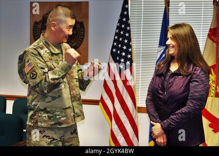 Oberst Hui Chae Kim überreicht Karin Hoying vom Resource Management Office (RMO) am 13. Januar 2020 eine Commander's Coin für Exzellenz, als Teil der Auszeichnung von Hoying mit dem Fort McCoy Garrison Civilian Employee of the Month für Dezember 2019. Hoying arbeitet als Senior Budget Analyst bei RMO und wurde für die Auszeichnung von Fort McCoy Resource Management Officer Maureen Richardson nominiert. (USA Army Photo von Scott T. Sturkol, Public Affairs Office, Fort McCoy, Wisp.) Stockfoto