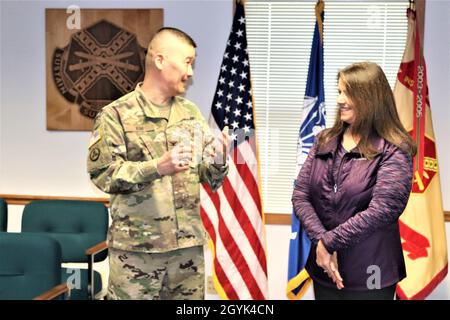 Oberst Hui Chae Kim überreicht Karin Hoying vom Resource Management Office (RMO) am 13. Januar 2020 eine Commander's Coin für Exzellenz, als Teil der Auszeichnung von Hoying mit dem Fort McCoy Garrison Civilian Employee of the Month für Dezember 2019. Hoying arbeitet als Senior Budget Analyst bei RMO und wurde für die Auszeichnung von Fort McCoy Resource Management Officer Maureen Richardson nominiert. (USA Army Photo von Scott T. Sturkol, Public Affairs Office, Fort McCoy, Wisp.) Stockfoto