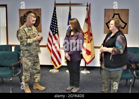 Oberst Hui Chae Kim überreicht Karin Hoying vom Resource Management Office (RMO) am 13. Januar 2020 eine Commander's Coin für Exzellenz, als Teil der Auszeichnung von Hoying mit dem Fort McCoy Garrison Civilian Employee of the Month für Dezember 2019. Hoying arbeitet als Senior Budget Analyst bei RMO und wurde für die Auszeichnung von Fort McCoy Resource Management Officer Maureen Richardson nominiert. (USA Army Photo von Scott T. Sturkol, Public Affairs Office, Fort McCoy, Wisp.) Stockfoto