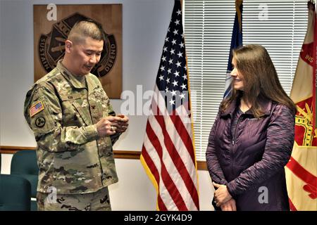 Oberst Hui Chae Kim überreicht Karin Hoying vom Resource Management Office (RMO) am 13. Januar 2020 eine Commander's Coin für Exzellenz, als Teil der Auszeichnung von Hoying mit dem Fort McCoy Garrison Civilian Employee of the Month für Dezember 2019. Hoying arbeitet als Senior Budget Analyst bei RMO und wurde für die Auszeichnung von Fort McCoy Resource Management Officer Maureen Richardson nominiert. (USA Army Photo von Scott T. Sturkol, Public Affairs Office, Fort McCoy, Wisp.) Stockfoto