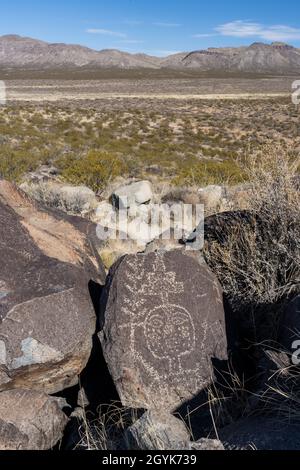 Ein menschliches Gesicht, das auf einem Basaltsteinbrocken in der Petroglyph-Stätte Three-Flues, New Mexico, geschnitzt wurde. Stockfoto