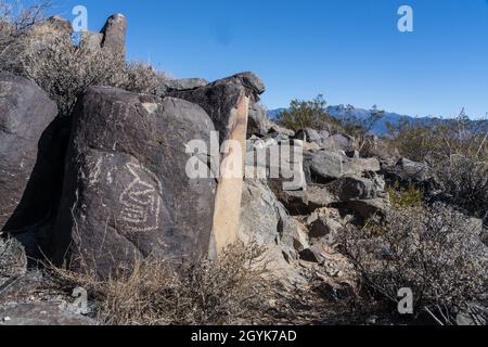 Eine anthropomorphe Figur, die auf einem Basaltsteinblock in der Petroglyph-Stätte Three Flueans, New Mexico, geschnitzt wurde. Stockfoto